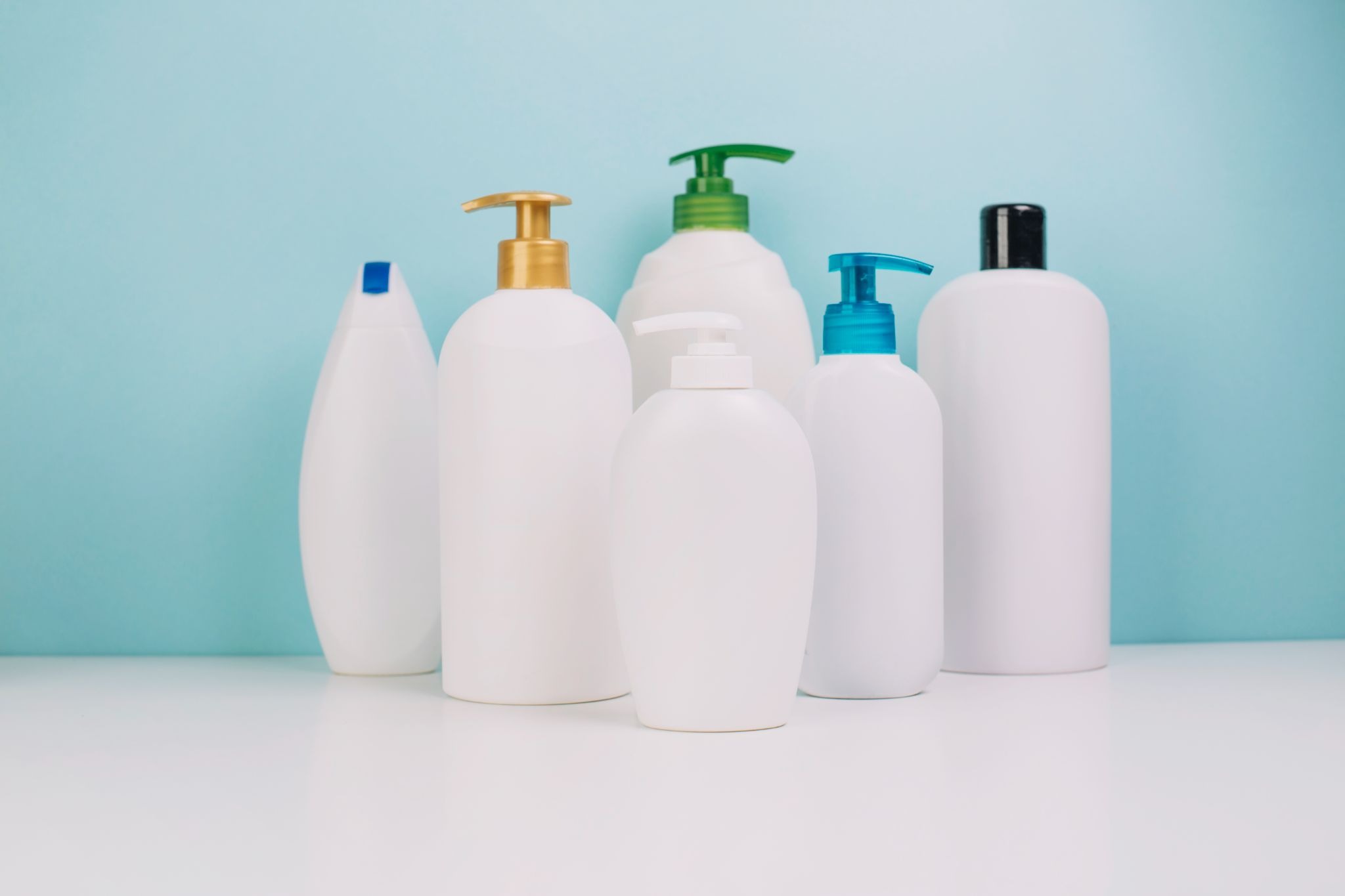 Collection of blank curl product bottles like the overwhelming hair care aisle, sorted by porosity and texture at a hair salon for curly hair in Gilbert.